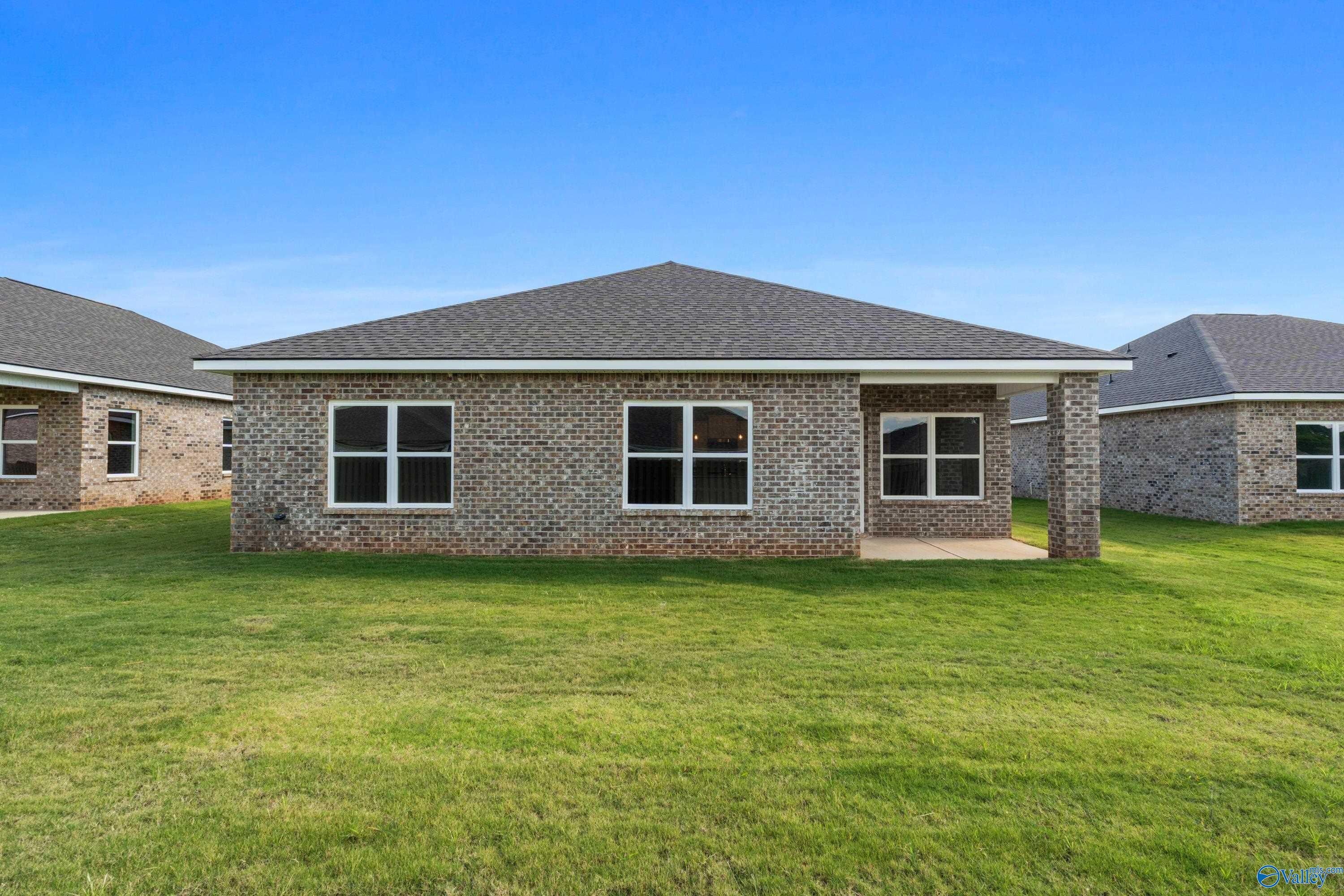 Single-story brick home with gable roof, covered porch, and green lawn in Clearview, Hazel Green, Alabama - Davidson Homes The Daphne