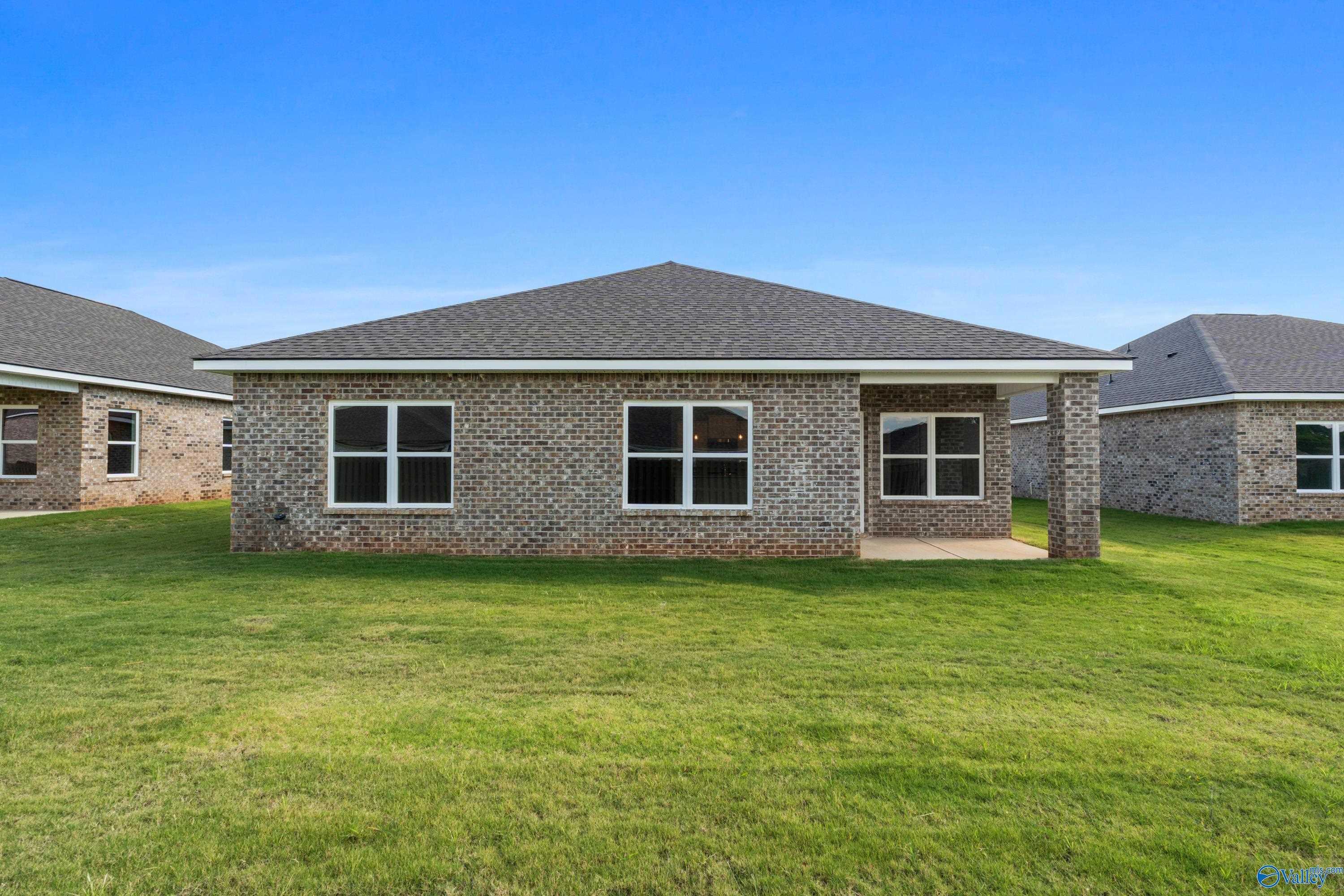 Single-story brick home with gable roof, covered porch, and green lawn in Clearview, Hazel Green, Alabama - Davidson Homes The Daphne