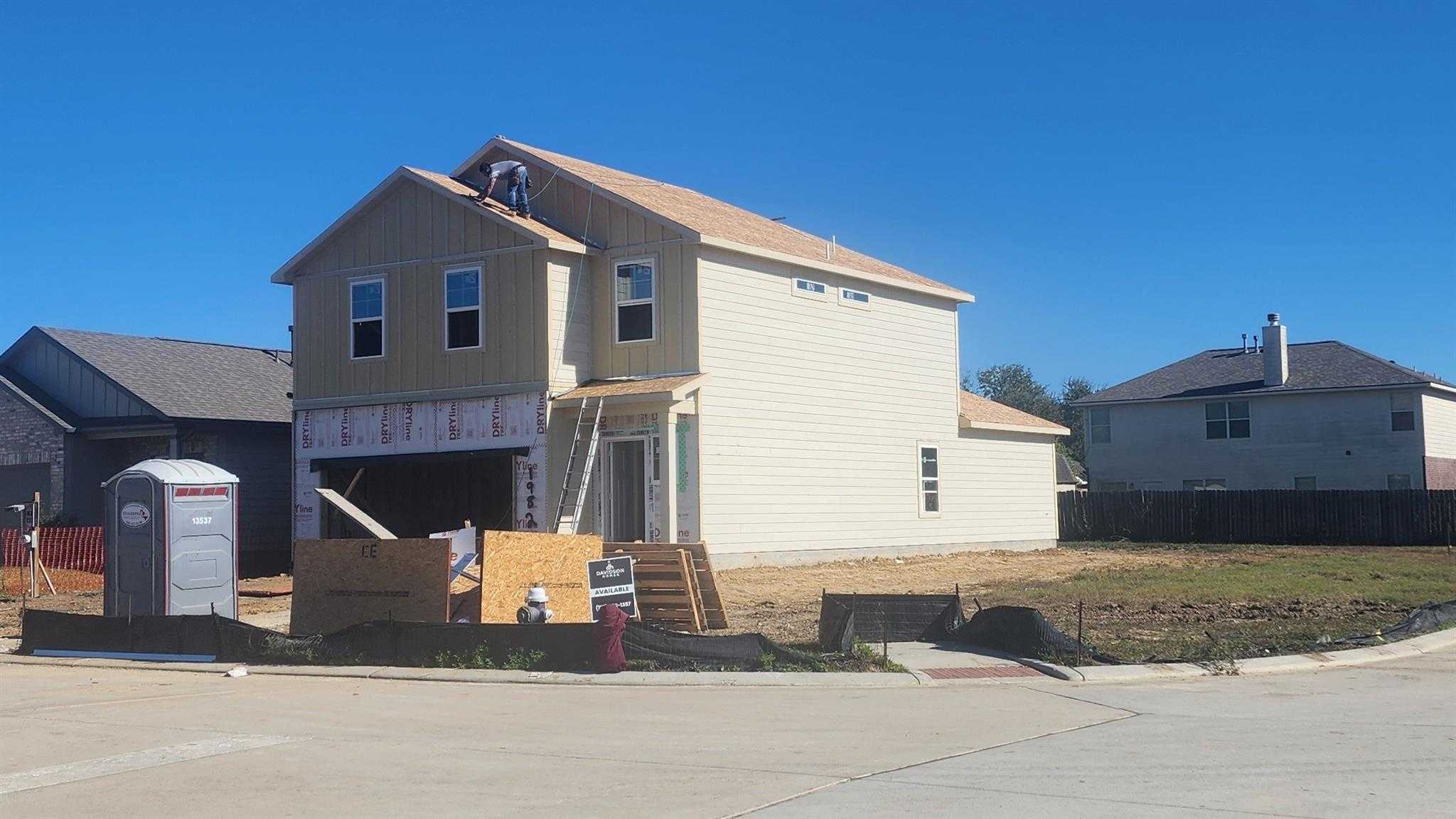 Under-construction two-story beige home with new roof and 2-car garage in The Villages at WestPointe, Dayton, Texas