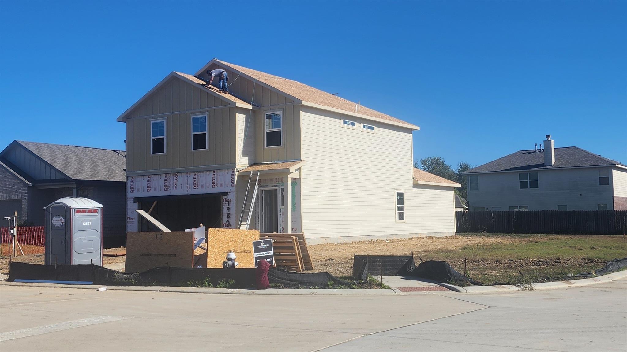 Under-construction two-story beige home with new roof and 2-car garage in The Villages at WestPointe, Dayton, Texas