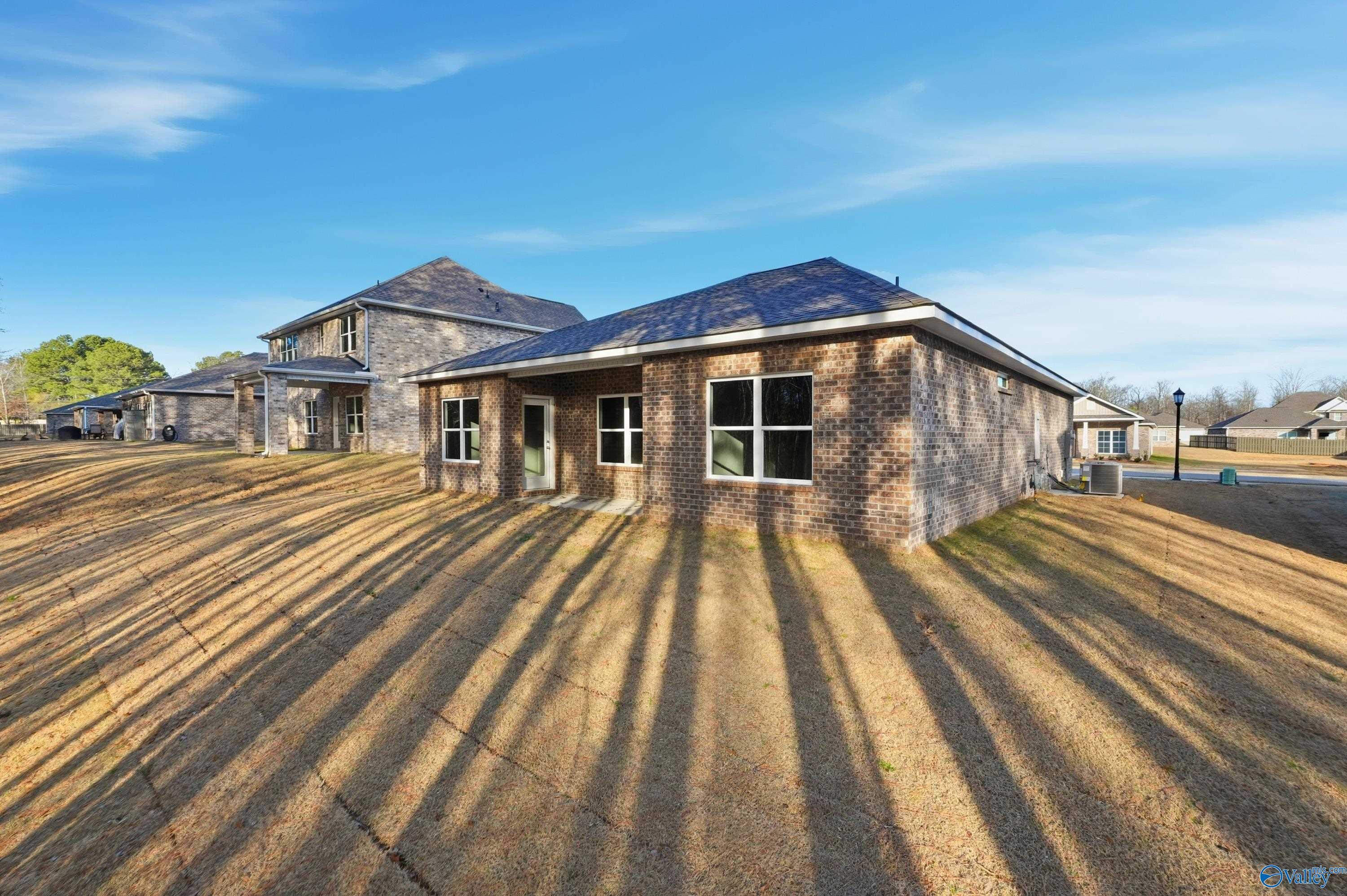 Brick single-story home with 2-car garage and large windows, The Asheville plan by Davidson Homes in The Highlands, Arab, Alabama