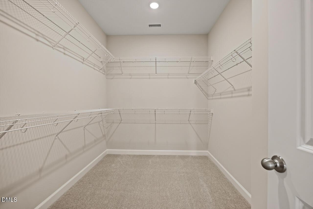 Walk-in closet with wire shelving in The Ash C floor plan at Woodland Crossing, Zebulon, North Carolina.