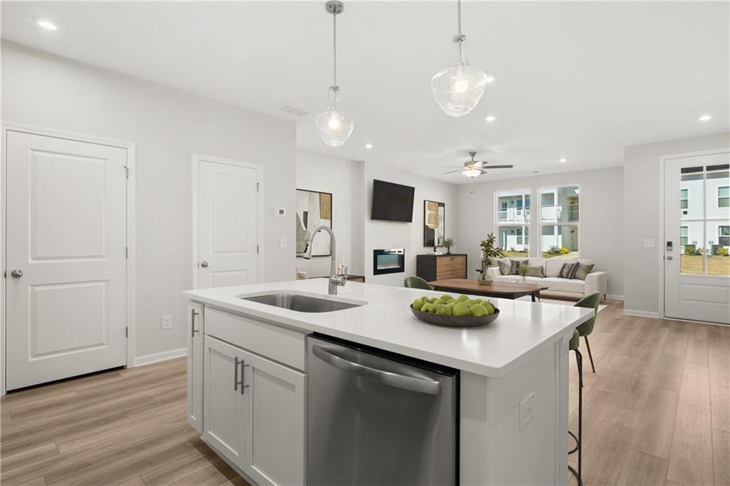 Open-concept kitchen and living area with quartz island in The Monroe B floor plan at Stegall Village, Emerson, Georgia.