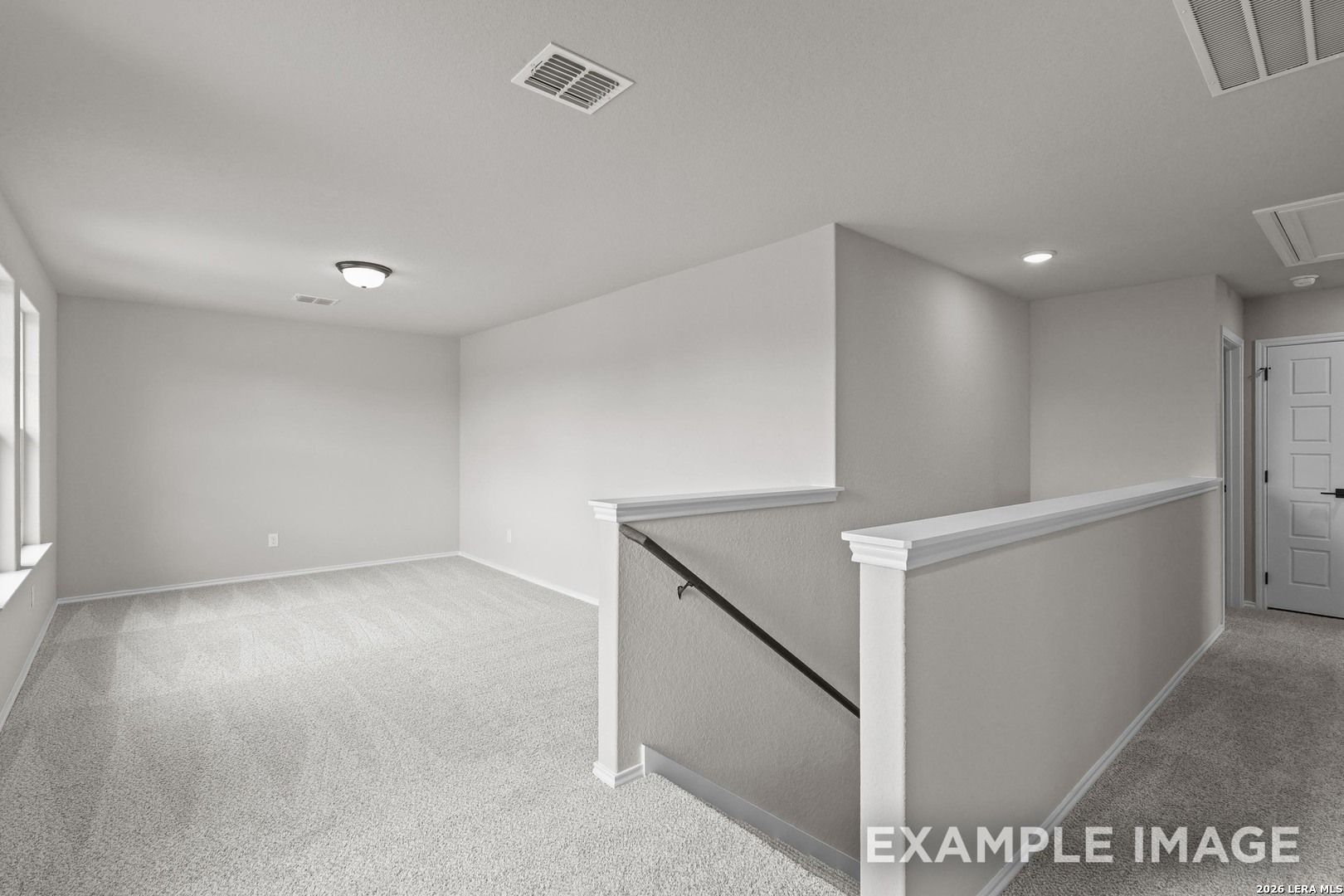 Spacious carpeted upstairs loft with staircase railing in Davidson Homes The Murray H floor plan, Converse, Texas new home
