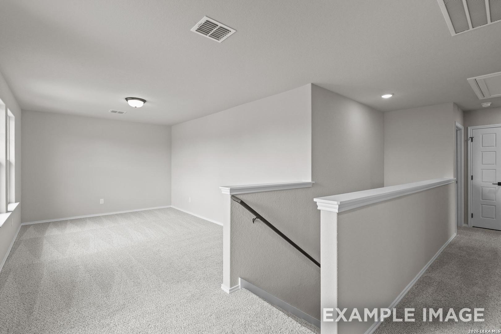 Spacious carpeted upstairs loft with staircase railing in Davidson Homes The Murray H floor plan, Converse, Texas new home