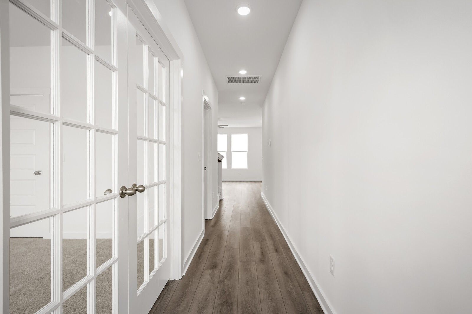 Bright hallway with French doors and wood-look flooring in The Logan C floor plan at Calista Farms, White House, TN.