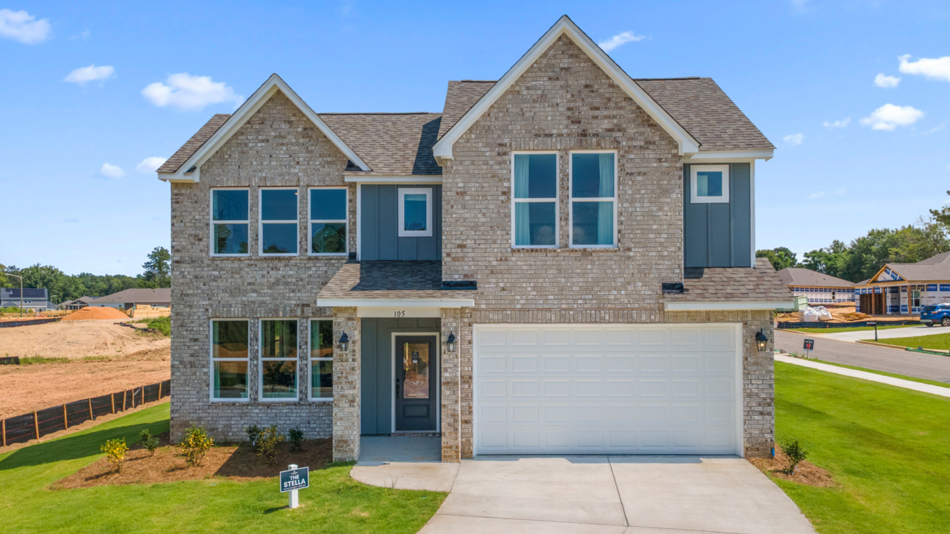 Spacious Links Crossing model home interior by Davidson Homes: white sectional sofa, gas fireplace, dining table, abstract art, plants