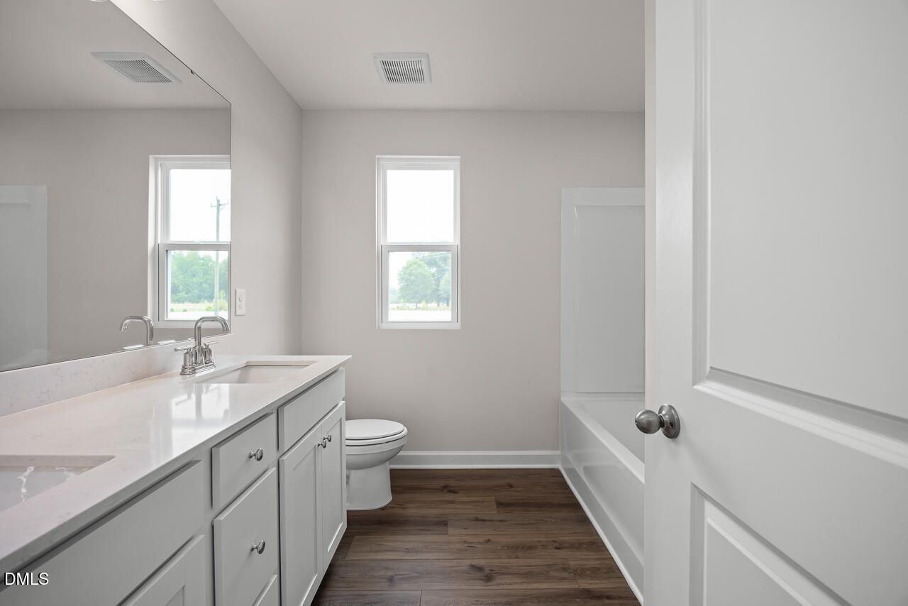 Modern bathroom with dual vanity and tub-shower combo in The Willow B floor plan at Woodland Crossing, Zebulon, NC.