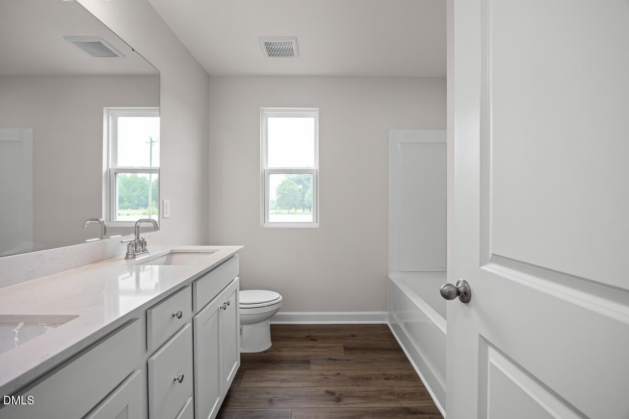 Modern bathroom with dual vanity and tub-shower combo in The Willow B floor plan at Woodland Crossing, Zebulon, NC.