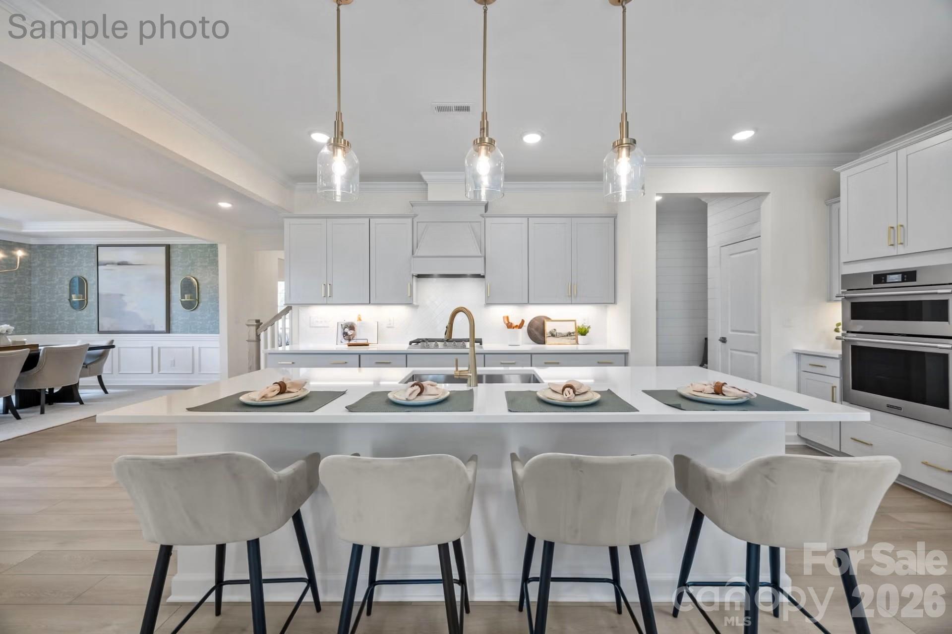 Modern kitchen island with bar seating in The Beech B floor plan at Enclave at Belmont, Belmont, North Carolina.