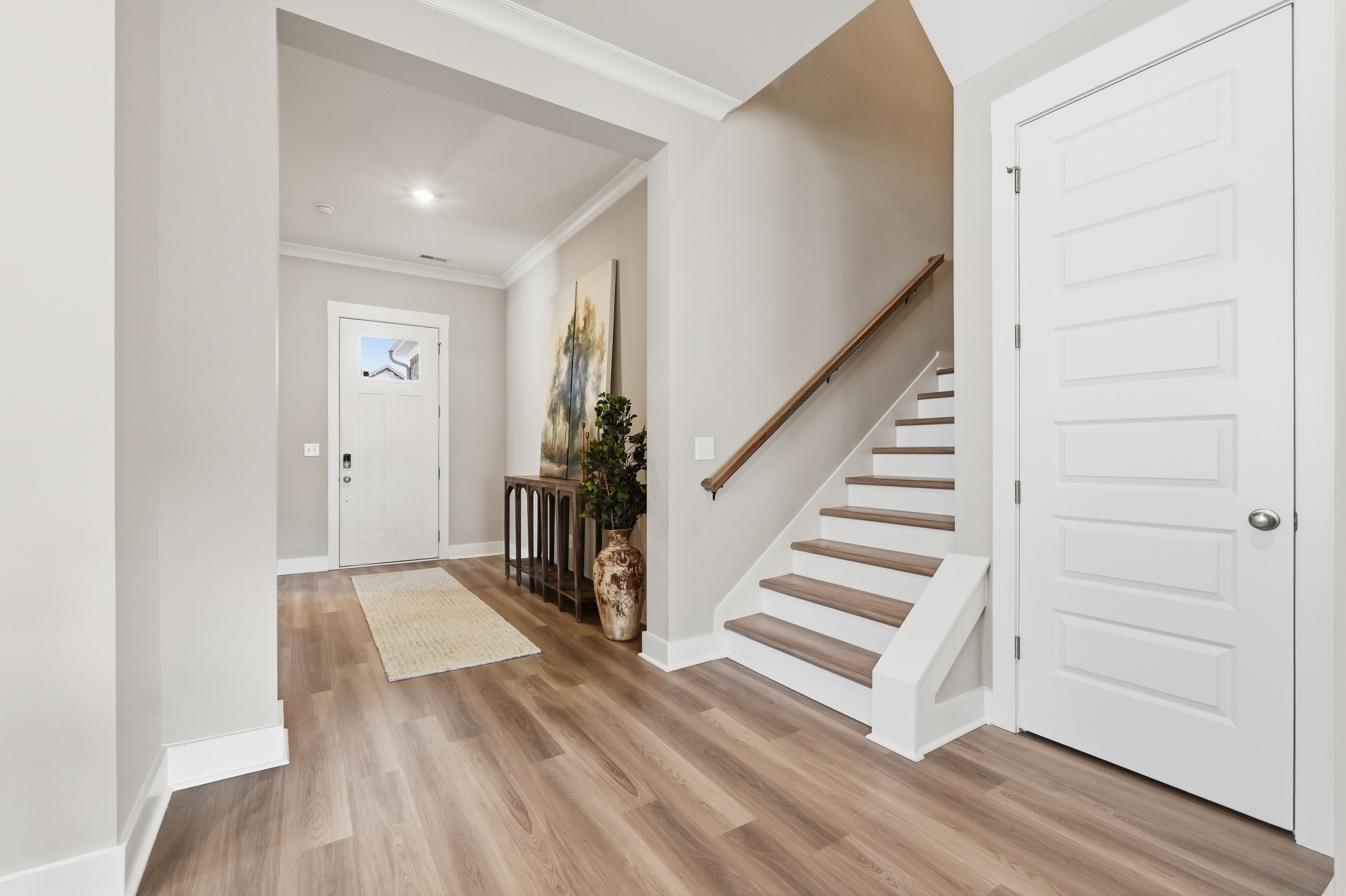 Spacious entryway at The Meadows at Hampton Cove in Owens Cross Roads AL with hardwood floors, staircase, and artwork