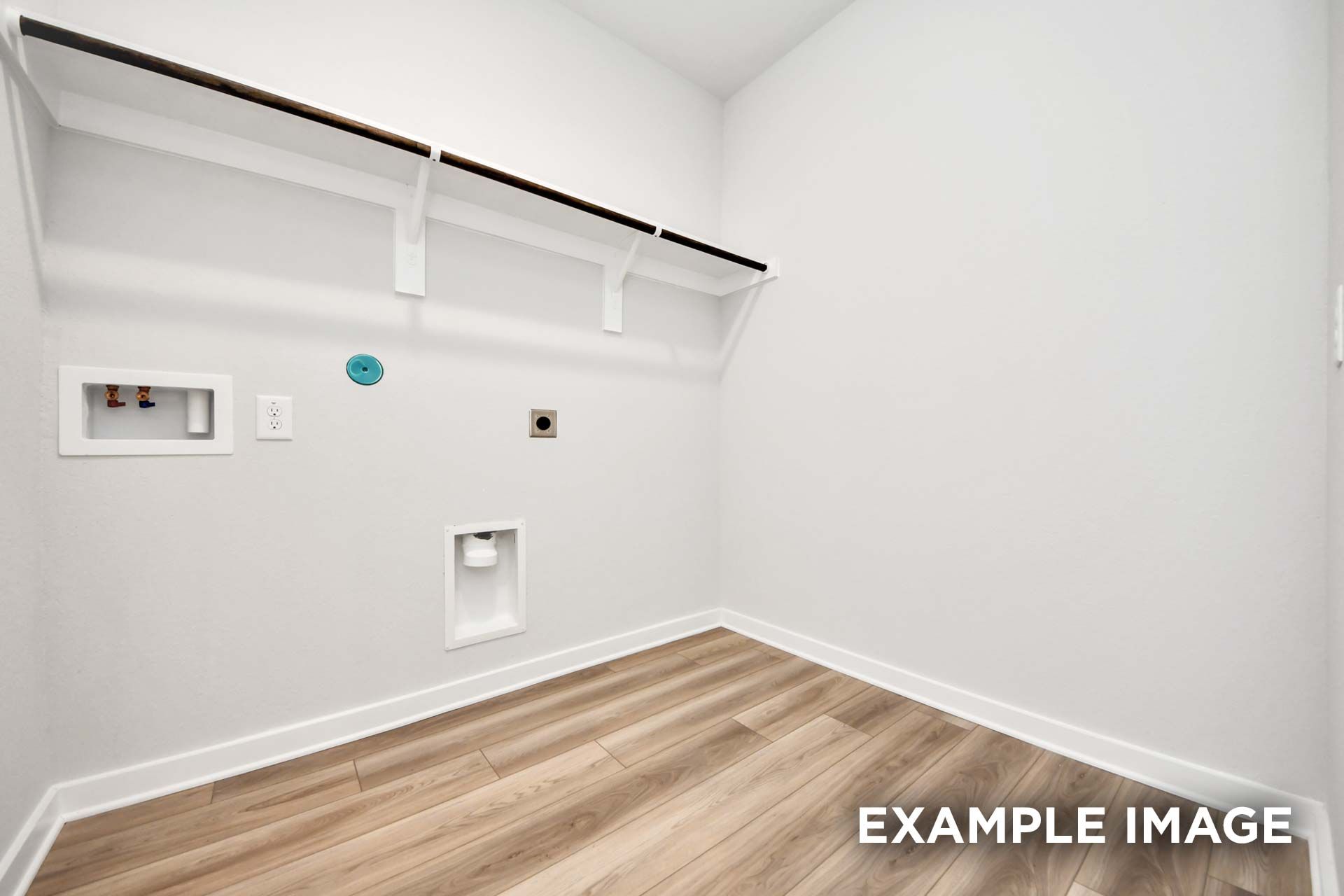 Spacious laundry room in The Sorrento featuring wood-look flooring and convenient overhead shelving for storage.