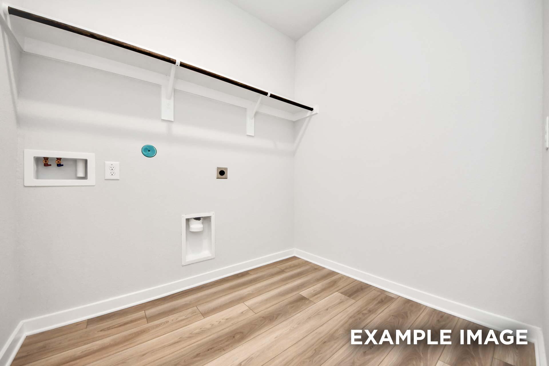 Spacious laundry room in The Sorrento featuring wood-look flooring and convenient overhead shelving for storage.