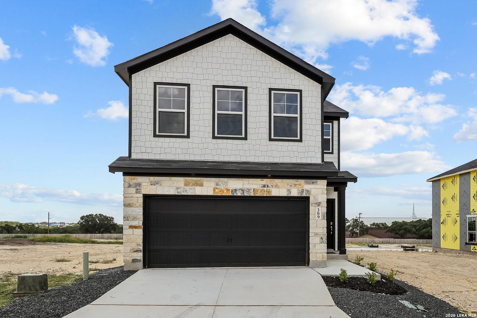 Two-story Gillian B floor plan by Davidson Homes with stone facade and 2-car garage in Meadows at Oak Creek, San Antonio.