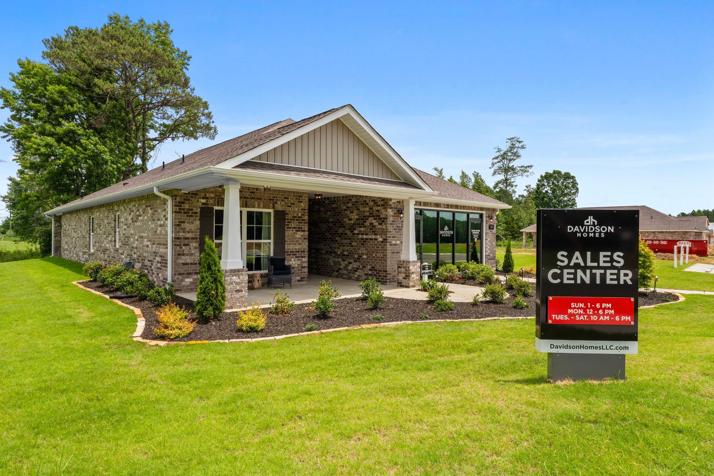 Davidson Homes sales center at The Highlands in Arab Alabama with stone facade, covered porch and landscaped yard
