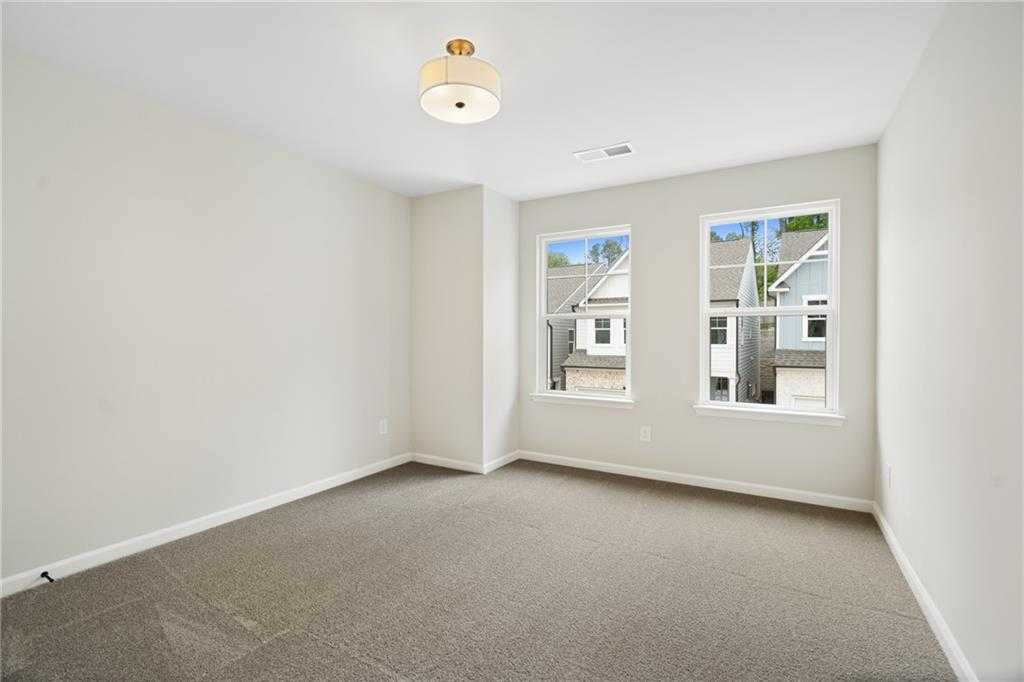 Bright secondary bedroom with large windows and neighborhood view in Davidson Homes The Marion A, Kennesaw, Georgia
