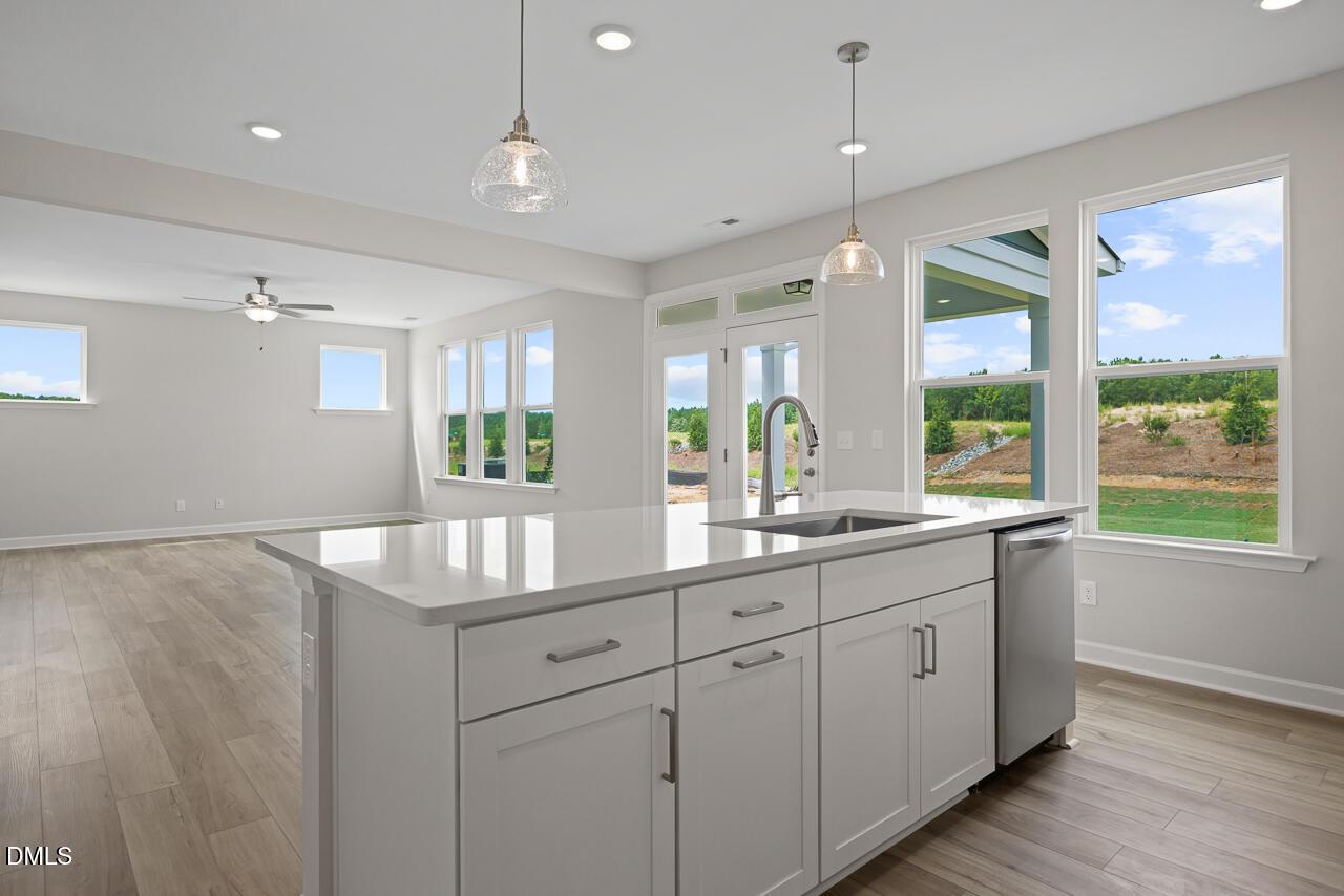 Modern kitchen island with quartz countertops in The Chestnut floor plan home at Wendell Ridge in Wendell, North Carolina.