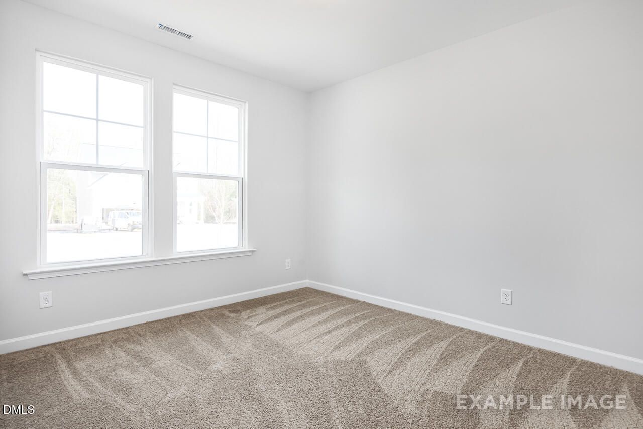 Bright secondary bedroom with double windows and beige carpet in The Daphne C floor plan, Lillington, NC