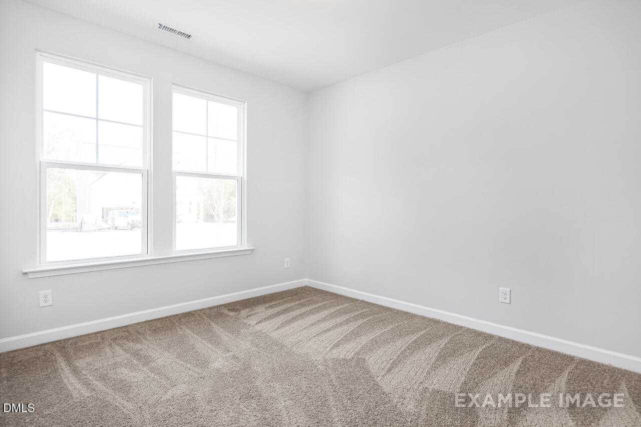 Bright secondary bedroom with double windows and beige carpet in The Daphne C floor plan, Lillington, NC