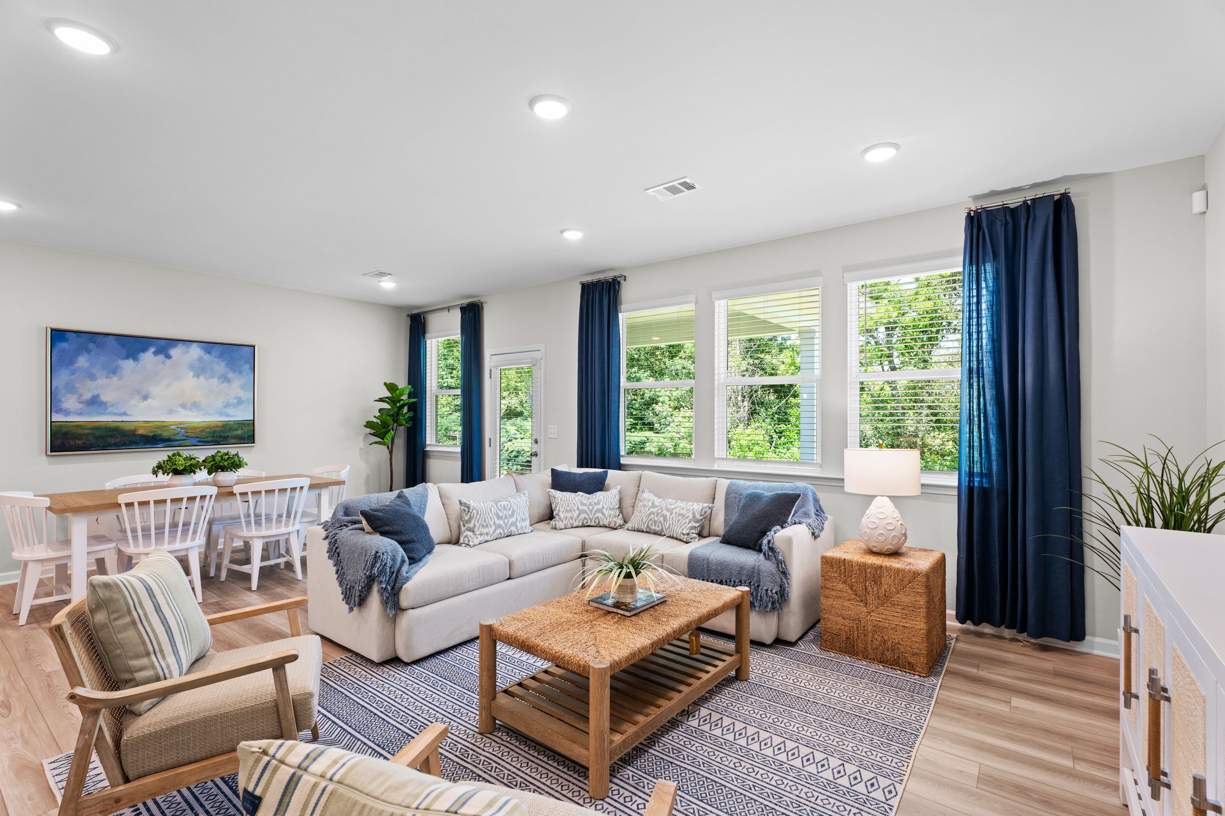 Decorated Living room with big beige sectional, coffee table and 2 chairs 