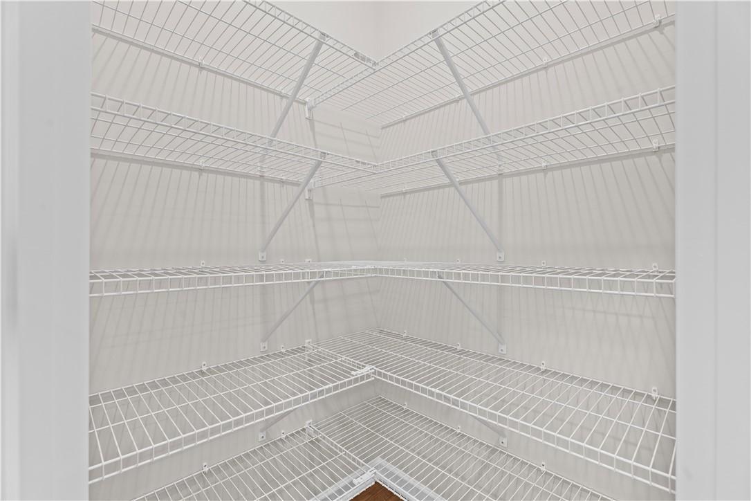 Spacious corner walk-in closet with white wire shelving in Evermore Homes The Orion, Cusseta, Alabama