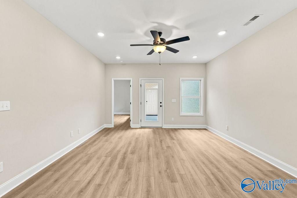 Bright living area with wood-look flooring and ceiling fan in The Camilla C floor plan at The Retreat at Cain Park.