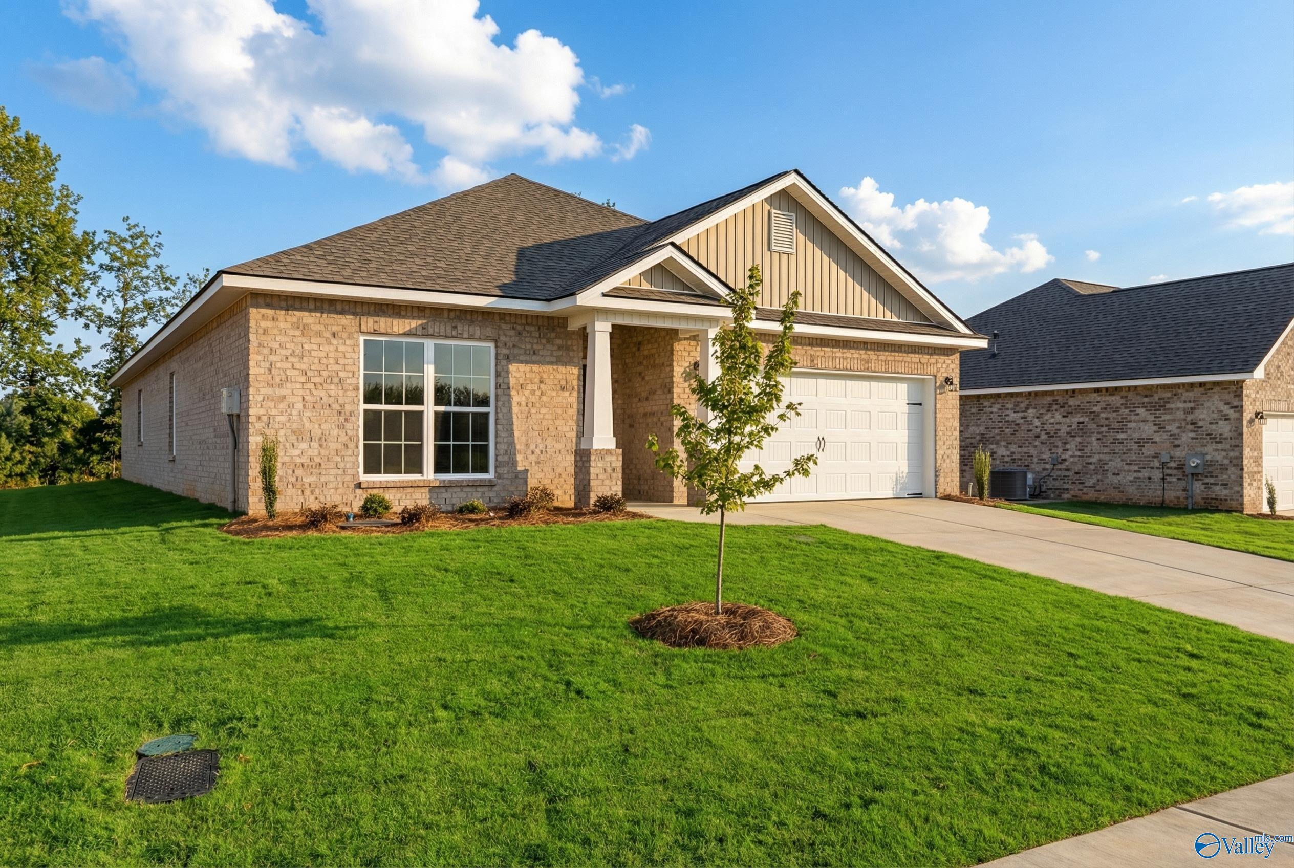 Modern brick 1-story home with 2-car garage, gabled roof, and lush lawn in Ivy Hills, Toney, Alabama - Davidson Homes The Daphne C
