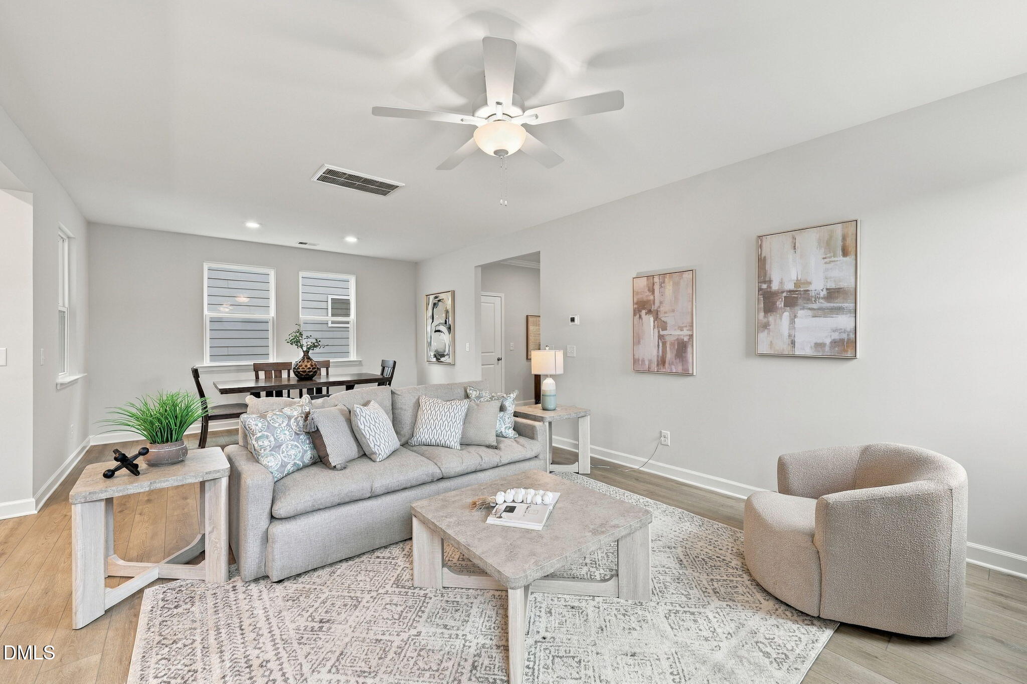 Bright open-concept living room with gray sofa and hardwood floors in Davidson Homes The Jordan C, Knightdale, North Carolina
