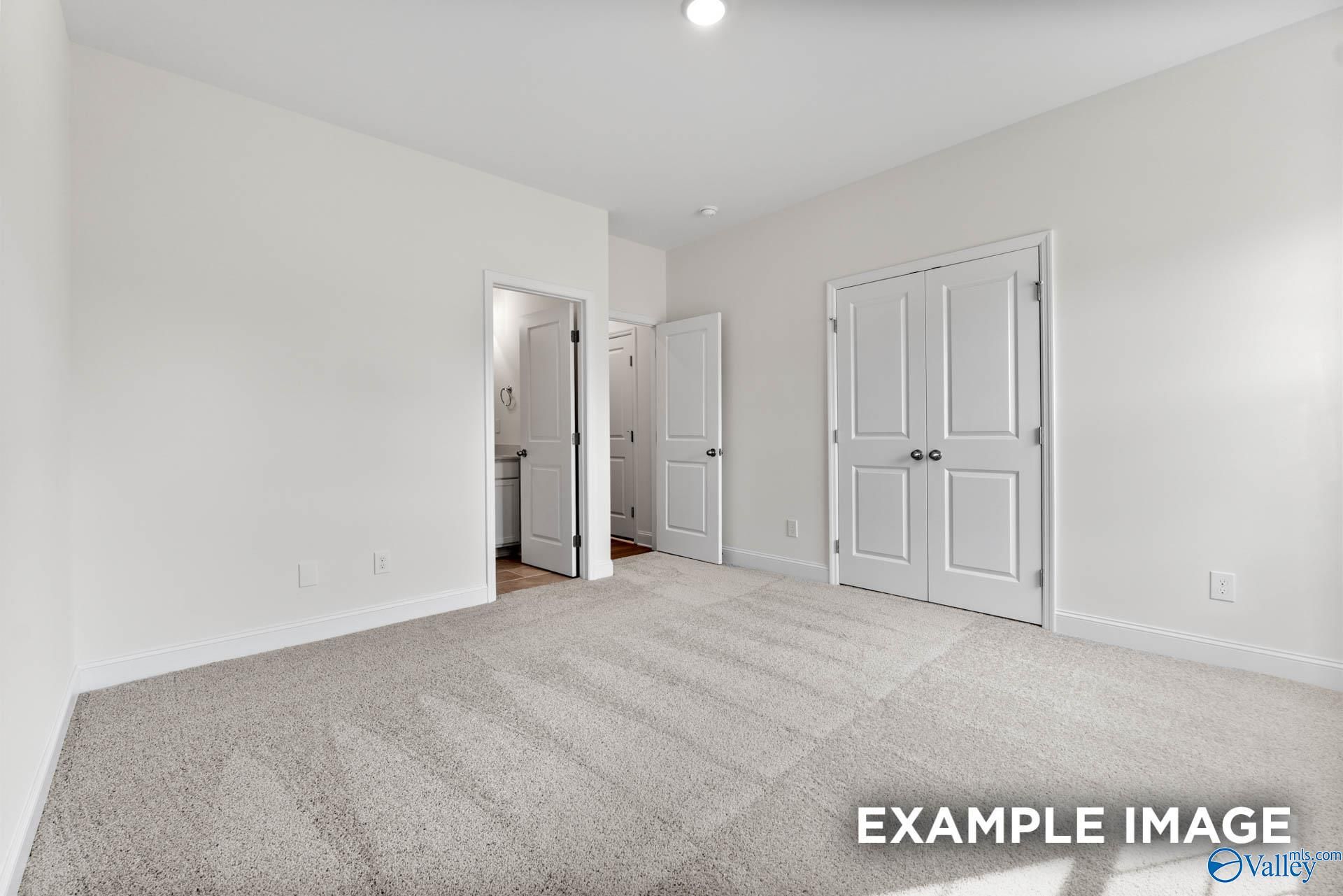 Spacious secondary bedroom with double-door closet and adjacent bath in Davidson Homes The Harrison C, Athens, Alabama