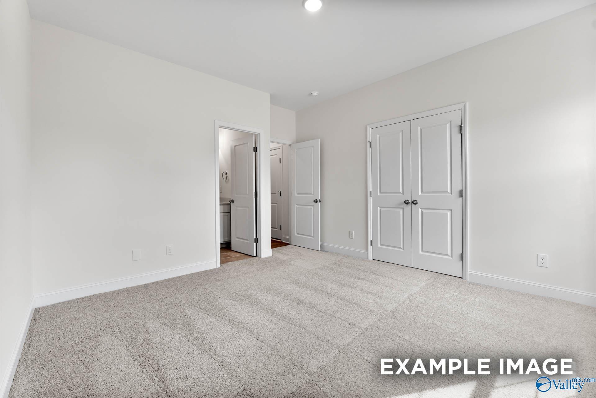 Spacious secondary bedroom with double-door closet and adjacent bath in Davidson Homes The Harrison C, Athens, Alabama