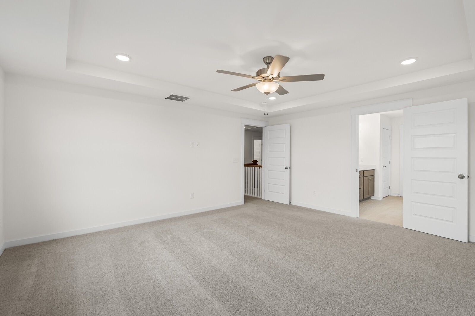 Spacious bedroom with tray ceiling and ceiling fan in The Henry C floor plan by Davidson Homes in Mt. Juliet, Tennessee.