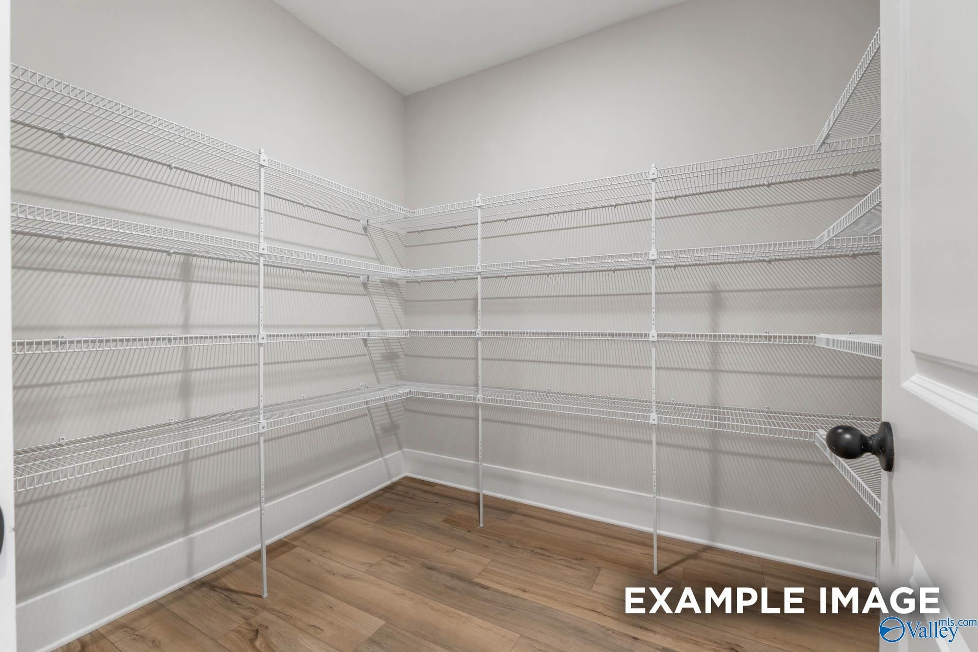 Walk-in pantry with white wire shelving and hardwood-style flooring in The Finleigh floor plan at Briercreek, Meridianville.