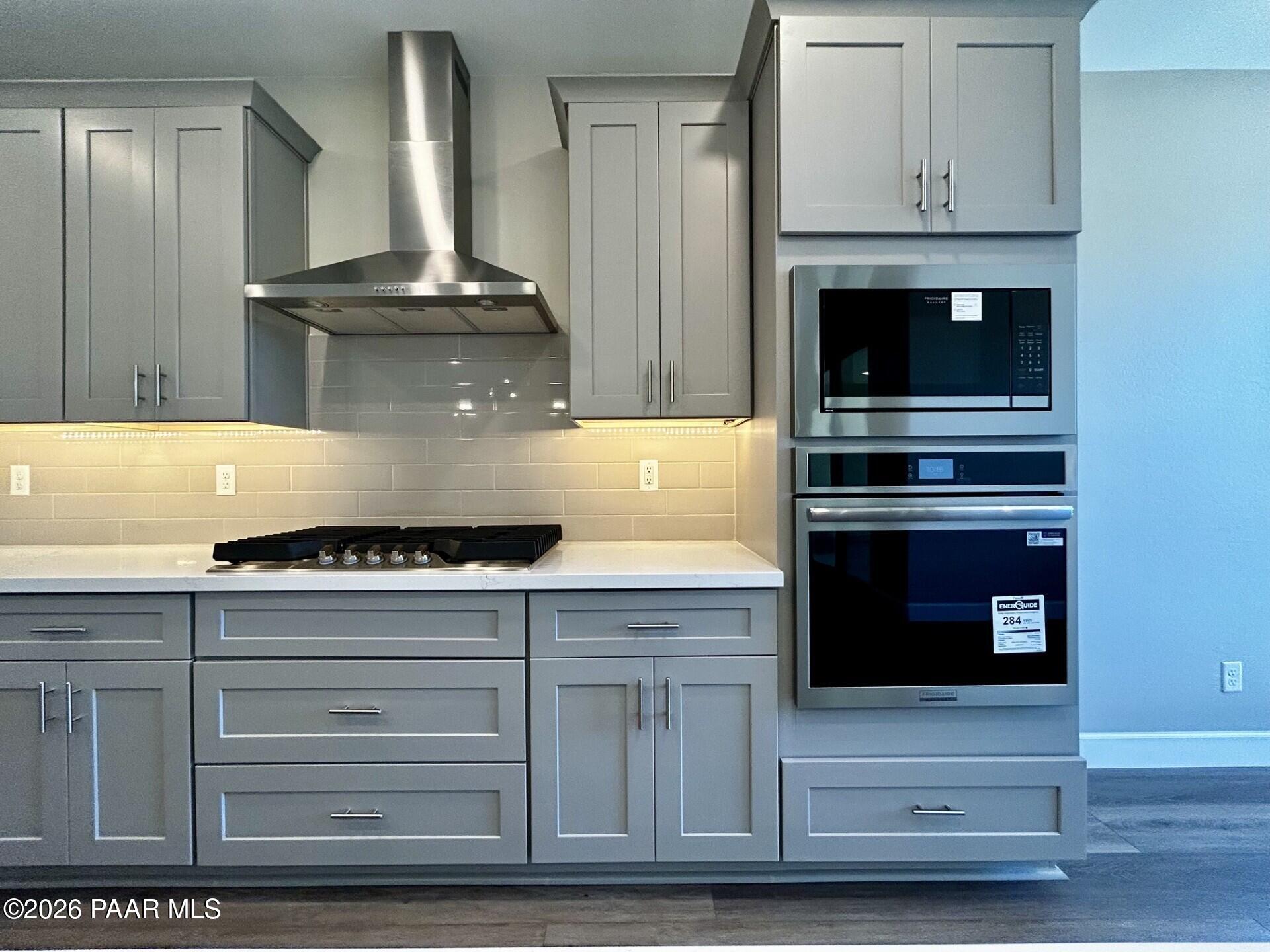 Modern gourmet kitchen with gray cabinets, stainless steel appliances, and gas range in Harmony C floor plan, Prescott Valley.