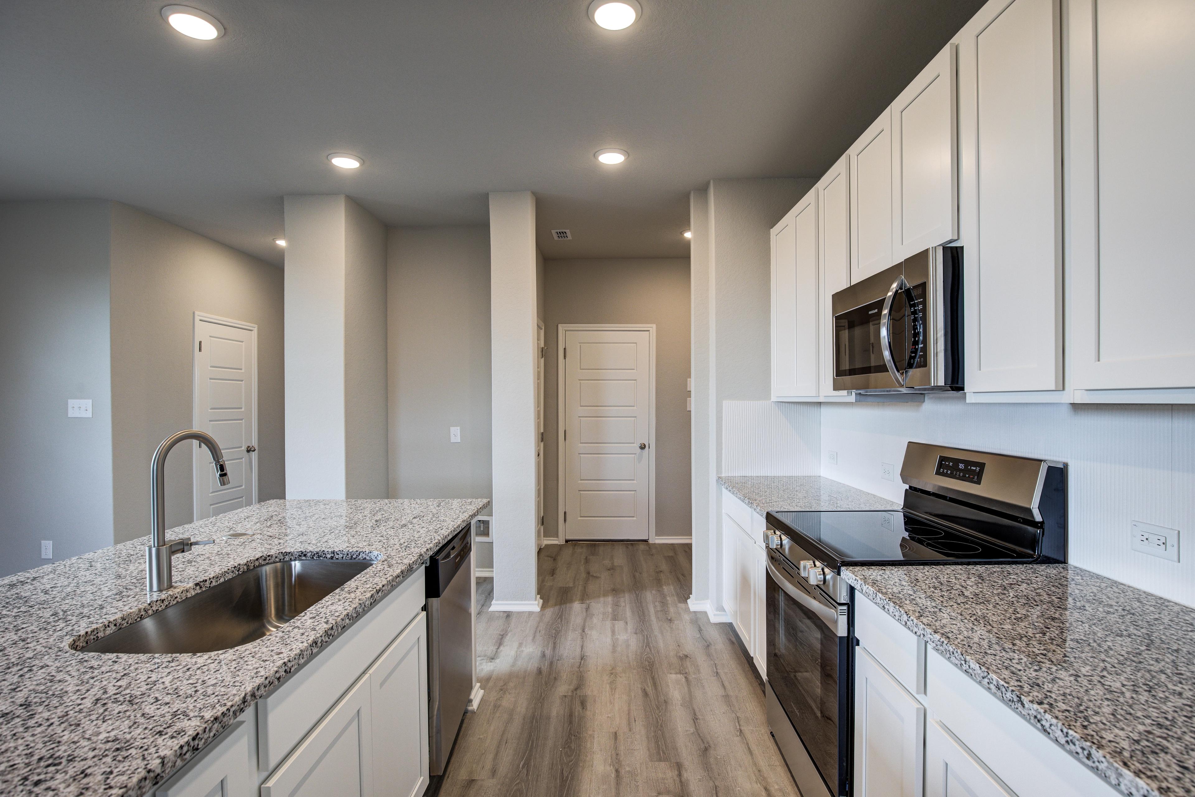 Spacious Blanco C kitchen with white shaker cabinets, granite island sink, stainless steel appliances, open layout