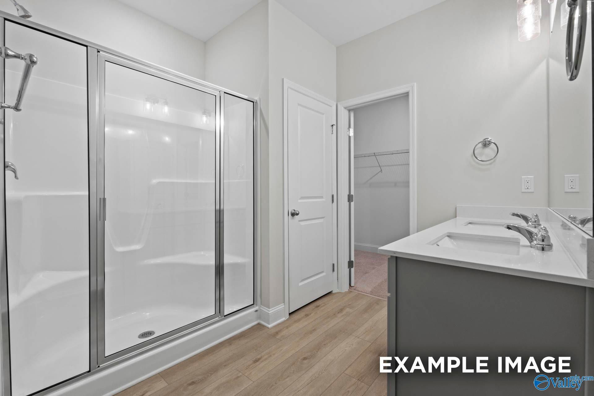 Modern master bathroom with glass-enclosed shower, dual vanity, and walk-in closet in Davidson Homes The Franklin C floor plan.