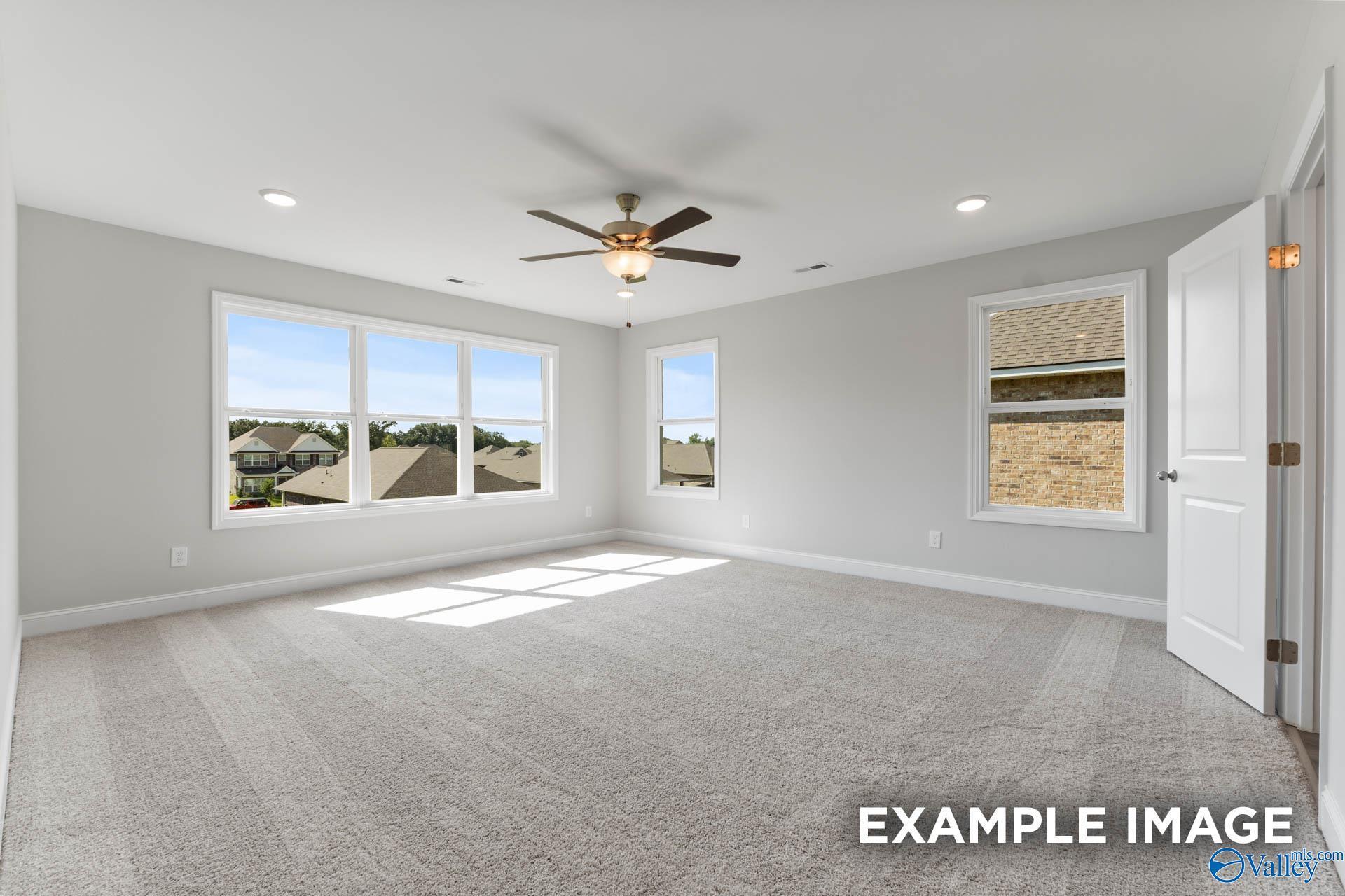 Bright bedroom with large windows, ceiling fan, and gray walls in The Chelsea D 4-bedroom home, New Market, Alabama
