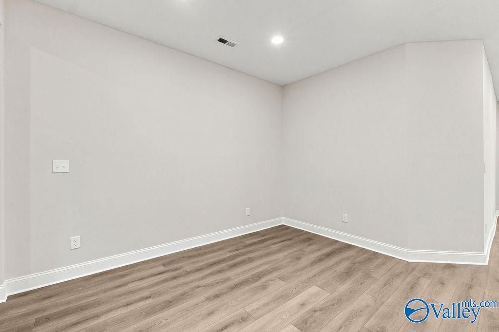 Bright, neutral-toned bedroom with wood-look flooring in The Camilla C floor plan at The Retreat at Cain Park, Hartselle.