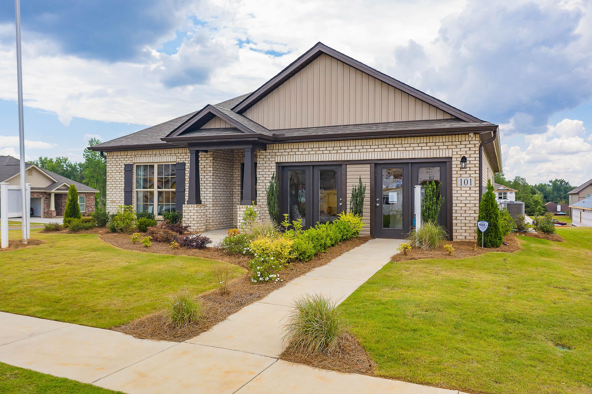 Contemporary brick and siding home exterior at Heritage Heights in Madison Alabama with covered porch and landscaped entry