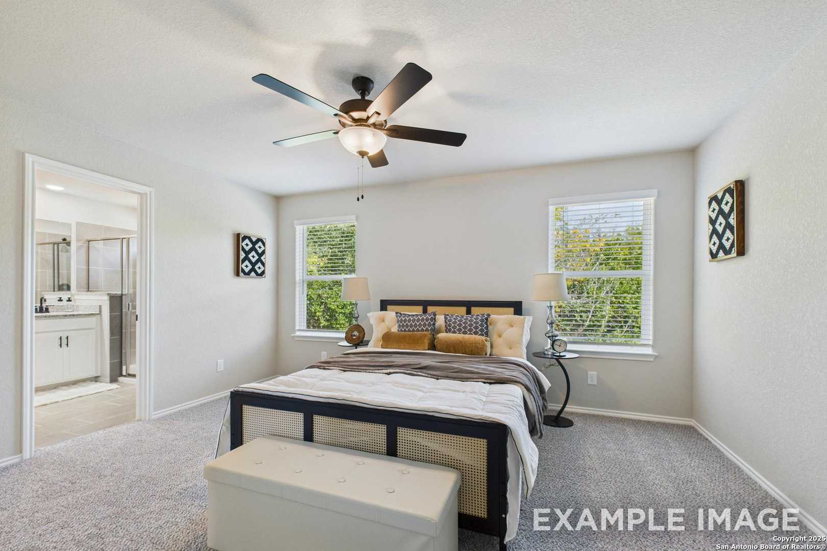 Master bedroom with king bed, ceiling fan, en-suite bath in Davidson Homes The Charlotte A, San Antonio, Texas