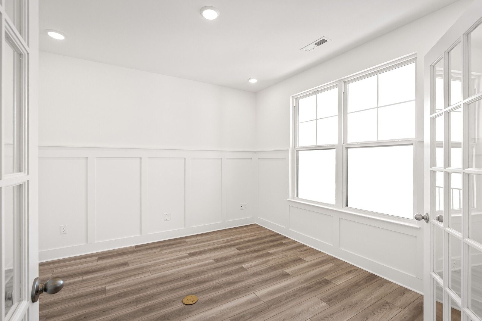 Bright dining room with white wainscoting, hardwood floors, large windows, French doors in Davidson Homes The Ash C, Mt. Juliet