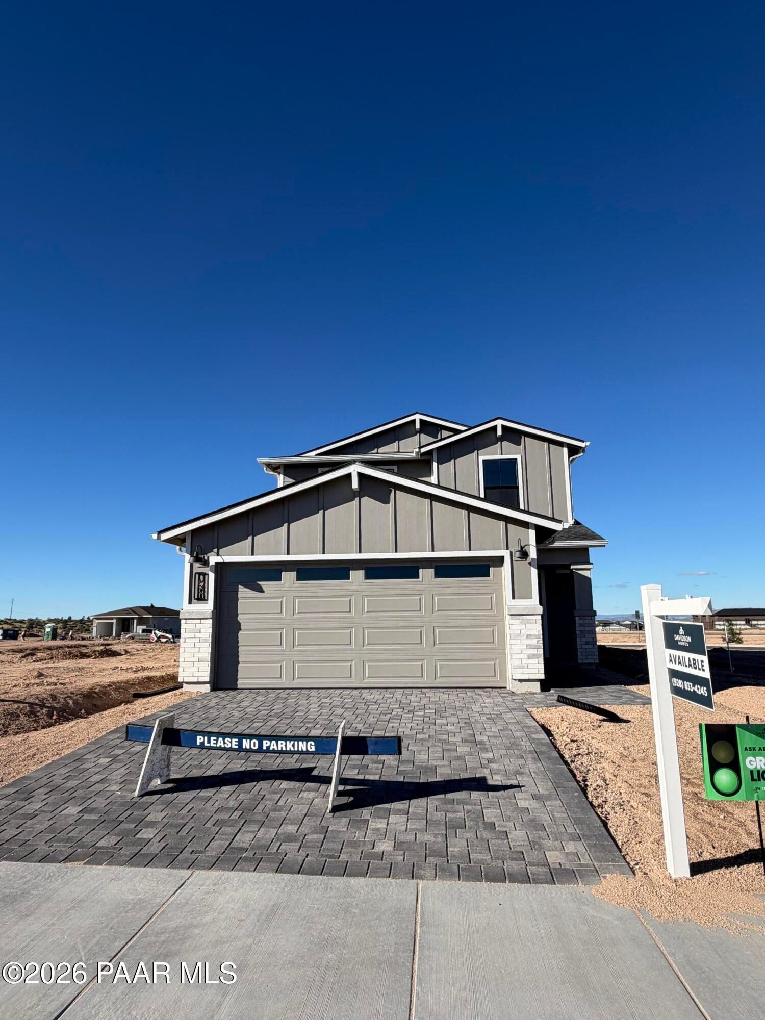 Two-story gray new construction home with 2-car garage and paver driveway at South Ranch Southern Collection, Prescott, Arizona