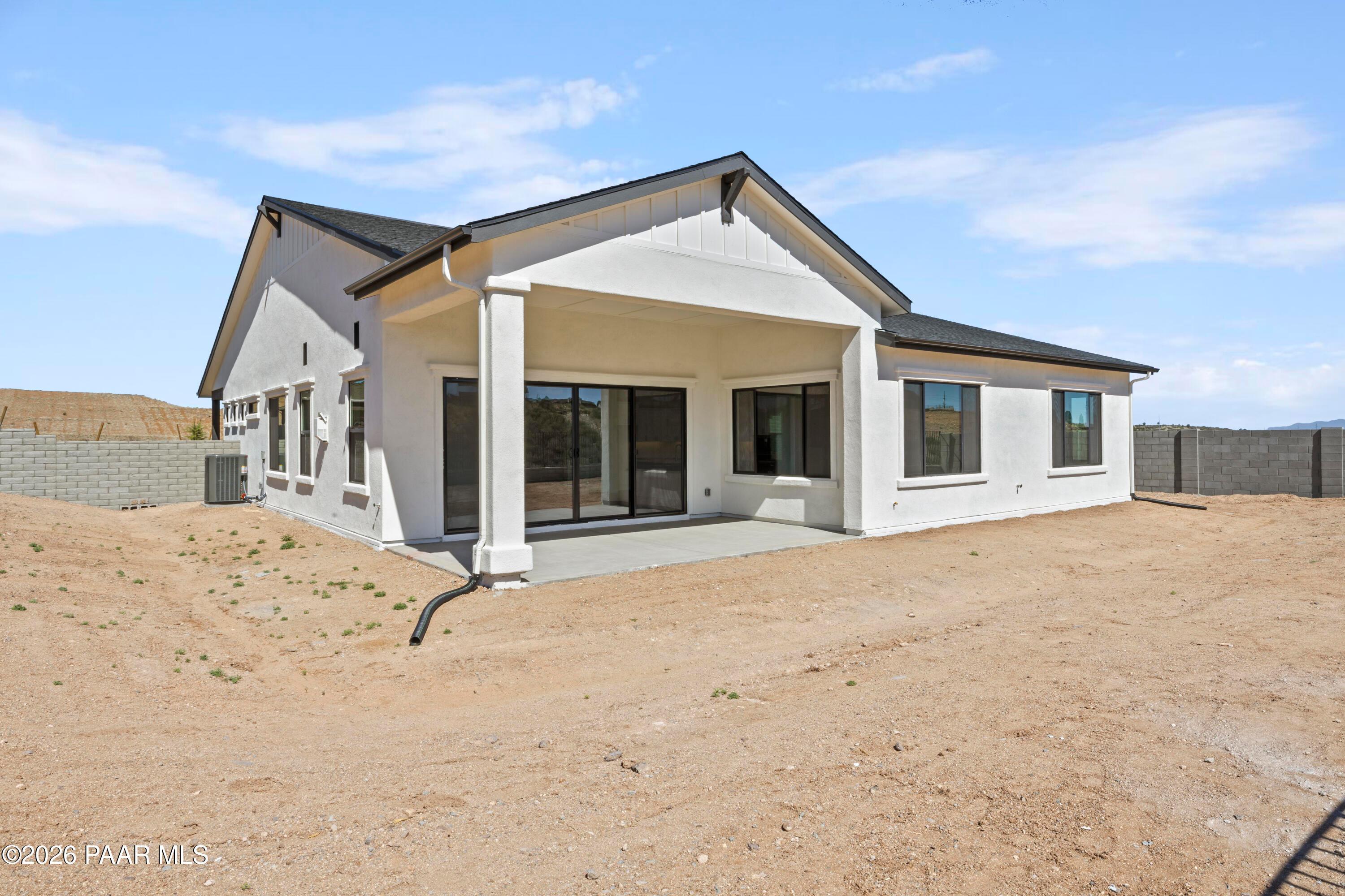 Back view of The Soleil E single-story home by Davidson Homes, white exterior with covered patio, sliding doors in Hidden Hills, Prescott, AZ