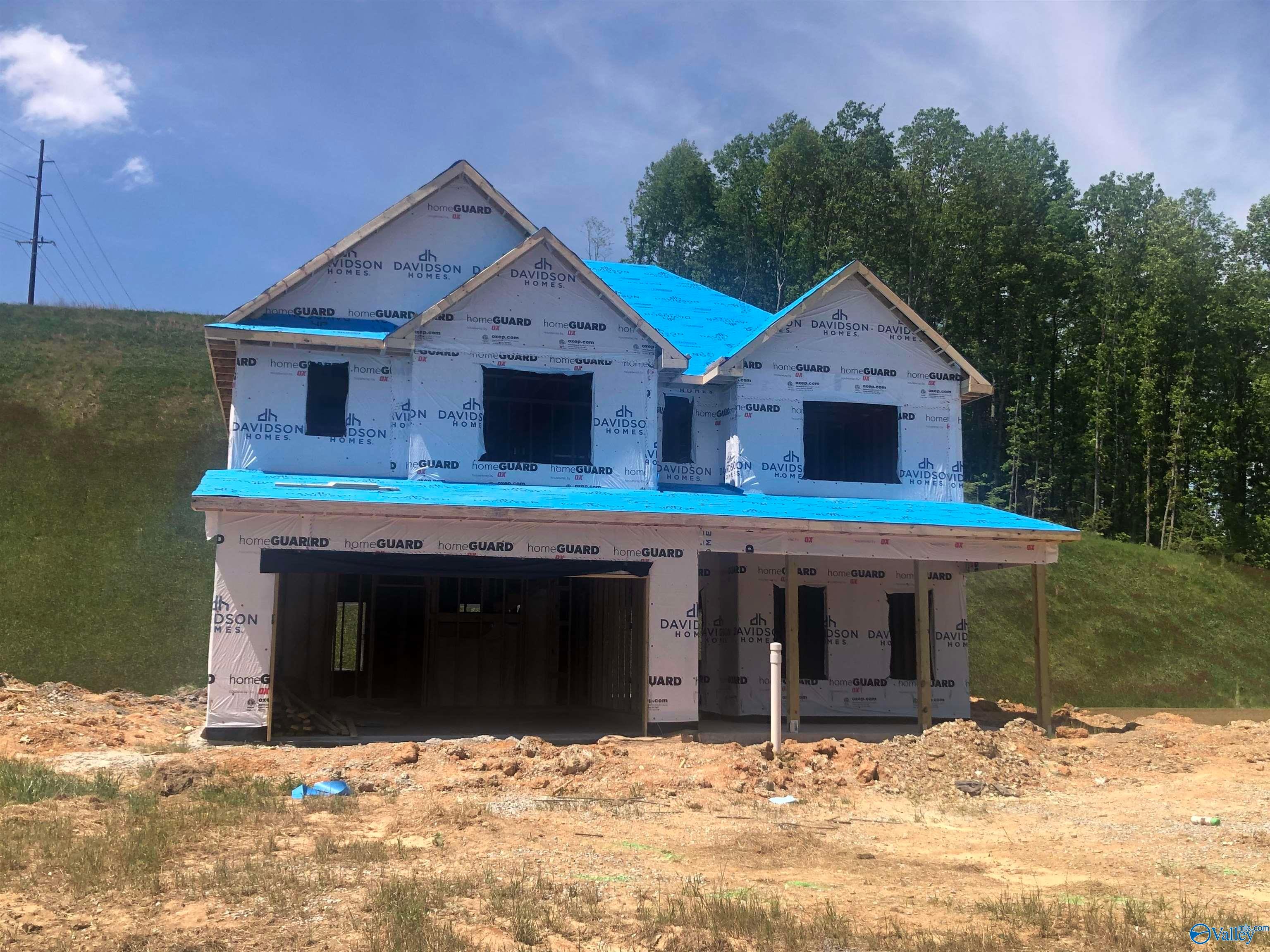 Framed two-story 4-bedroom home with blue roof and 2-car garage under construction in Noble Ridge, Cullman, Alabama - Davidson Homes The Shelby D