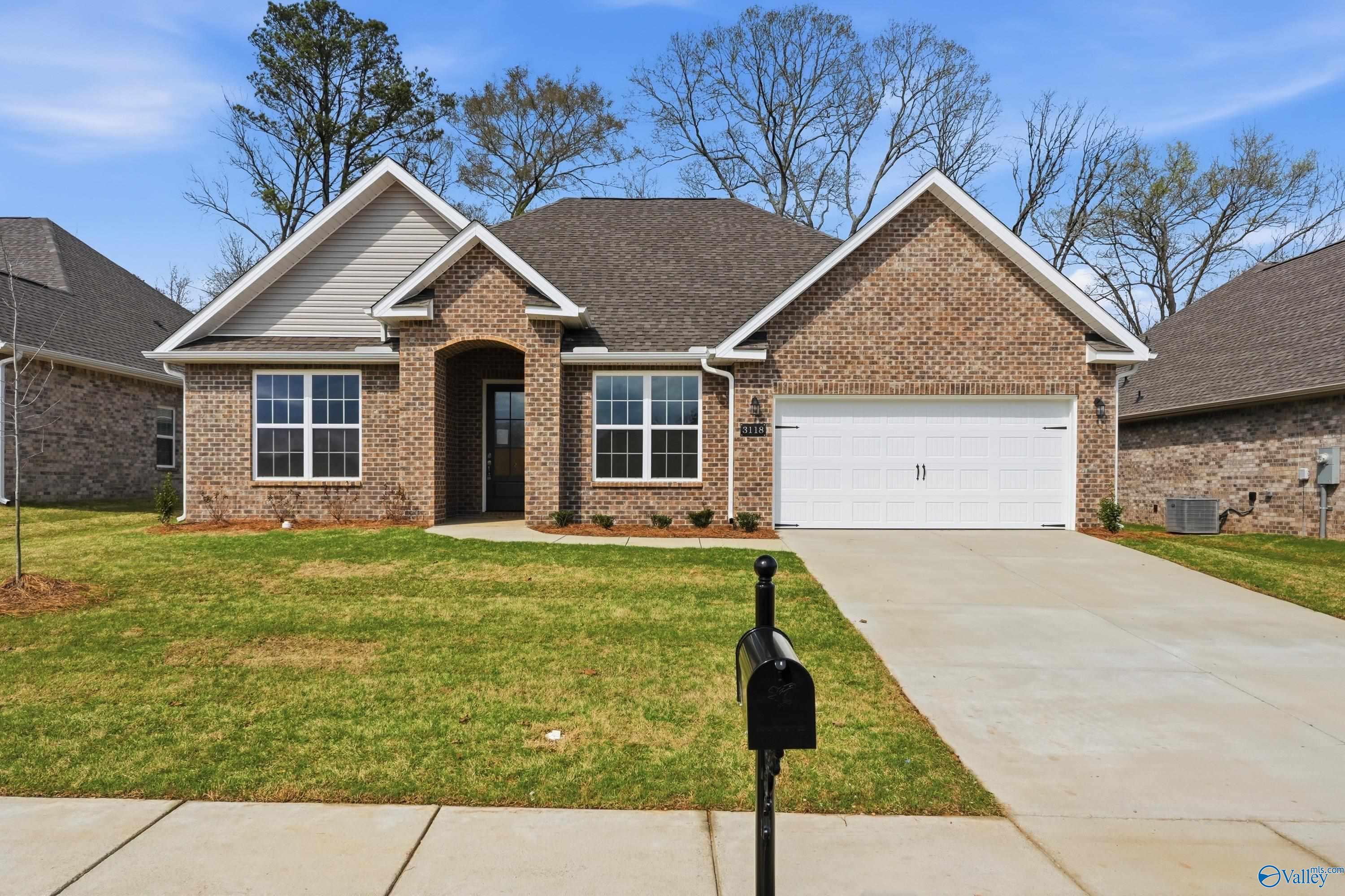 Brick 1-story home with 2-car garage, arched entry, and landscaped yard in River Road Estates, Decatur, Alabama