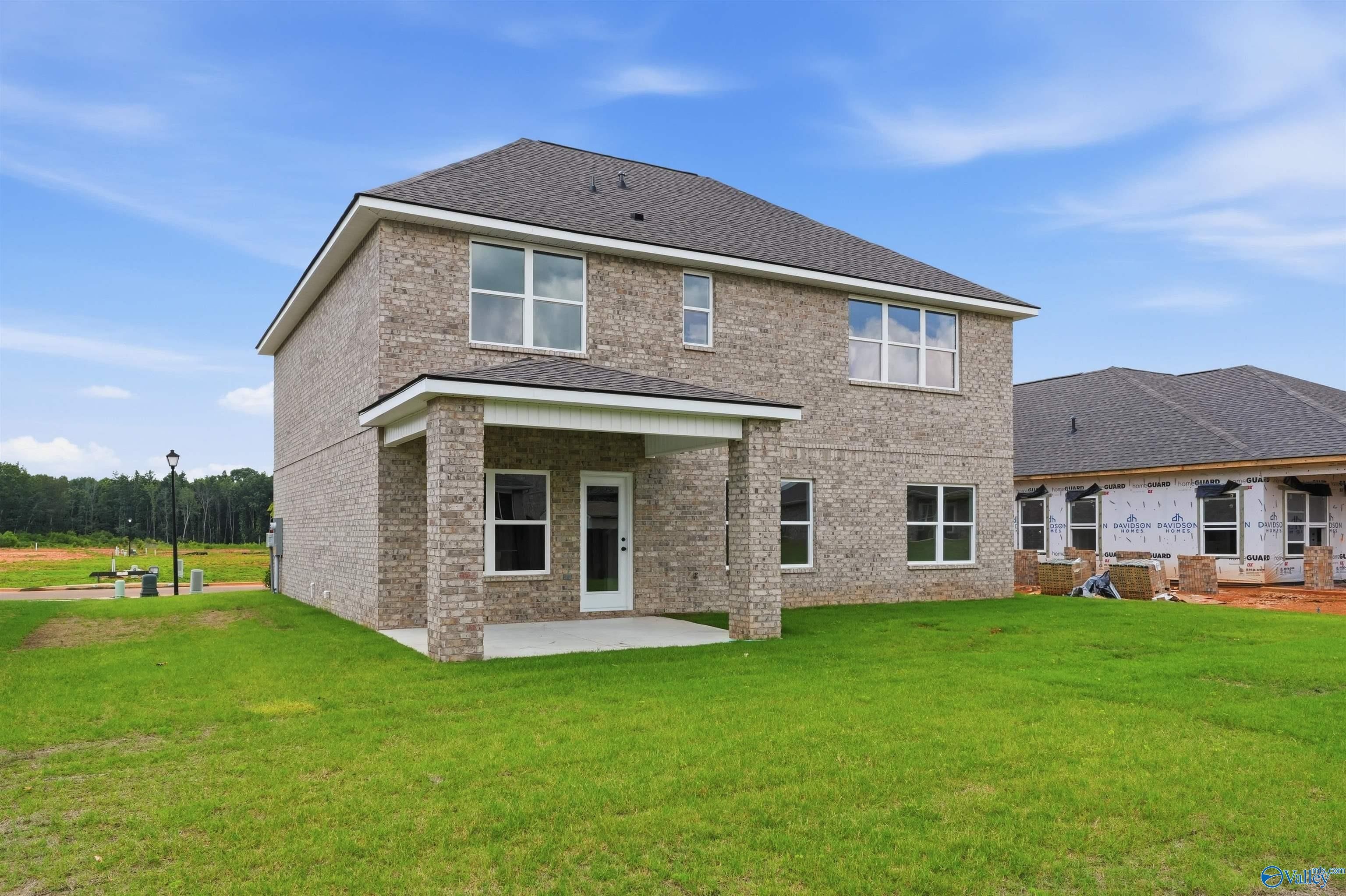 Two-story brick exterior with covered back patio for The Shelby A floor plan at Wood Trail in Toney, Alabama.