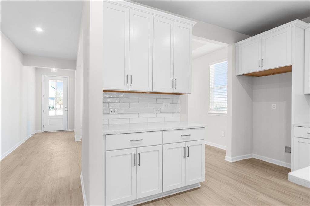 Modern kitchen butler's pantry with white cabinets and subway tile backsplash in The Glenwood A at Wehunt Meadows, Hoschton.
