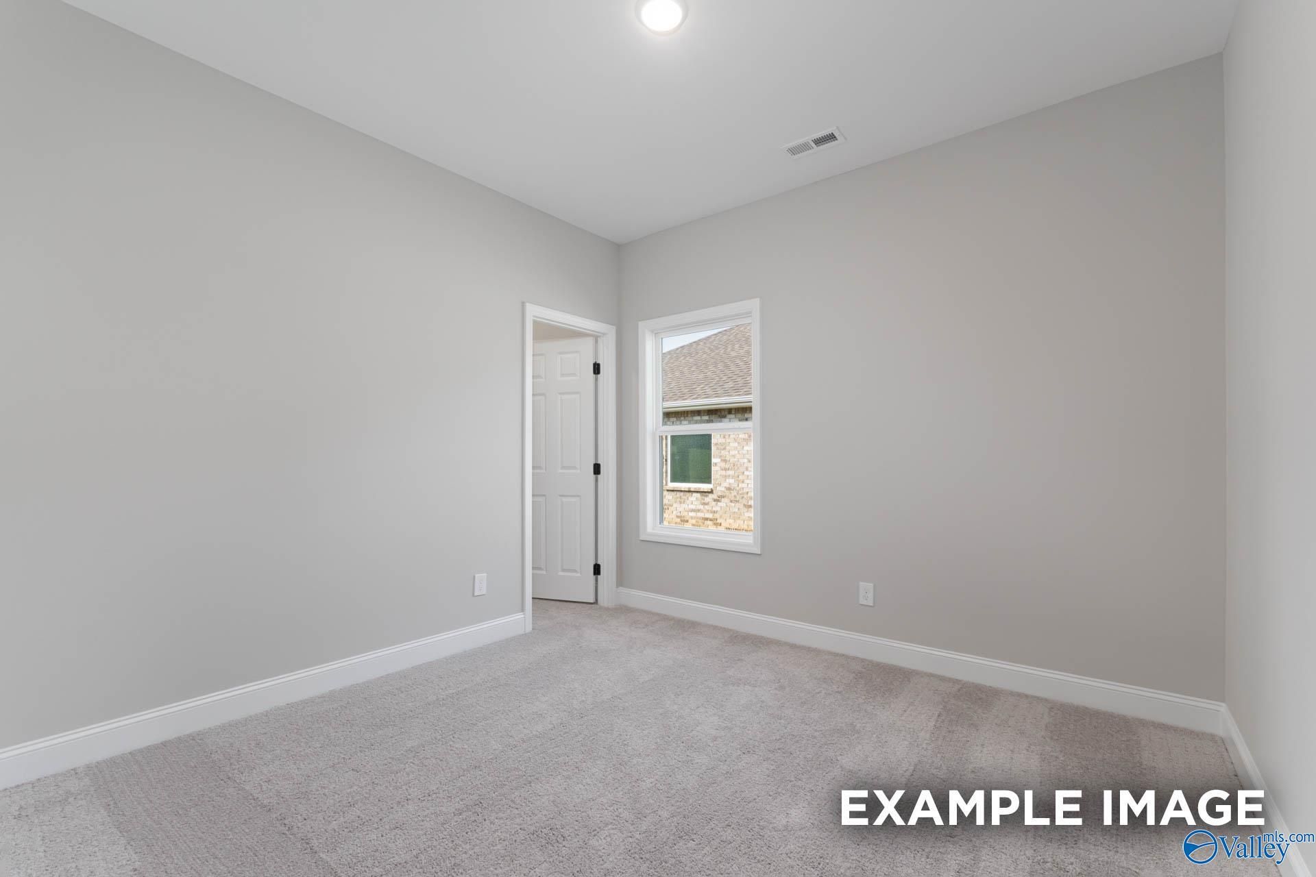 Spacious secondary bedroom with gray walls, carpet floor, and window in Davidson Homes The Daphne D, Meridianville, Alabama
