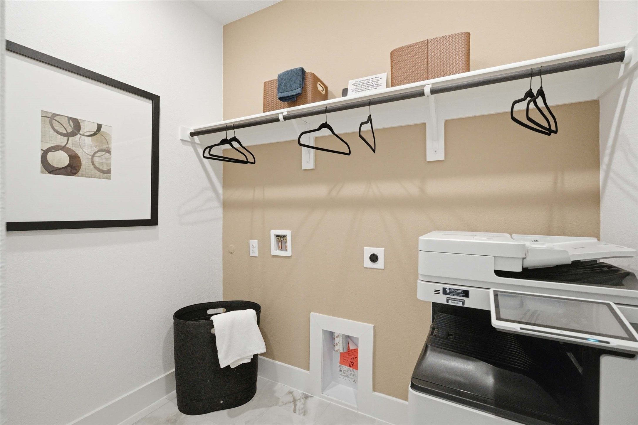 Laundry room with hanging rod, storage shelf, and washer in Davidson Homes The Laurel N plan, Mercer Meadows, Royse City, TX