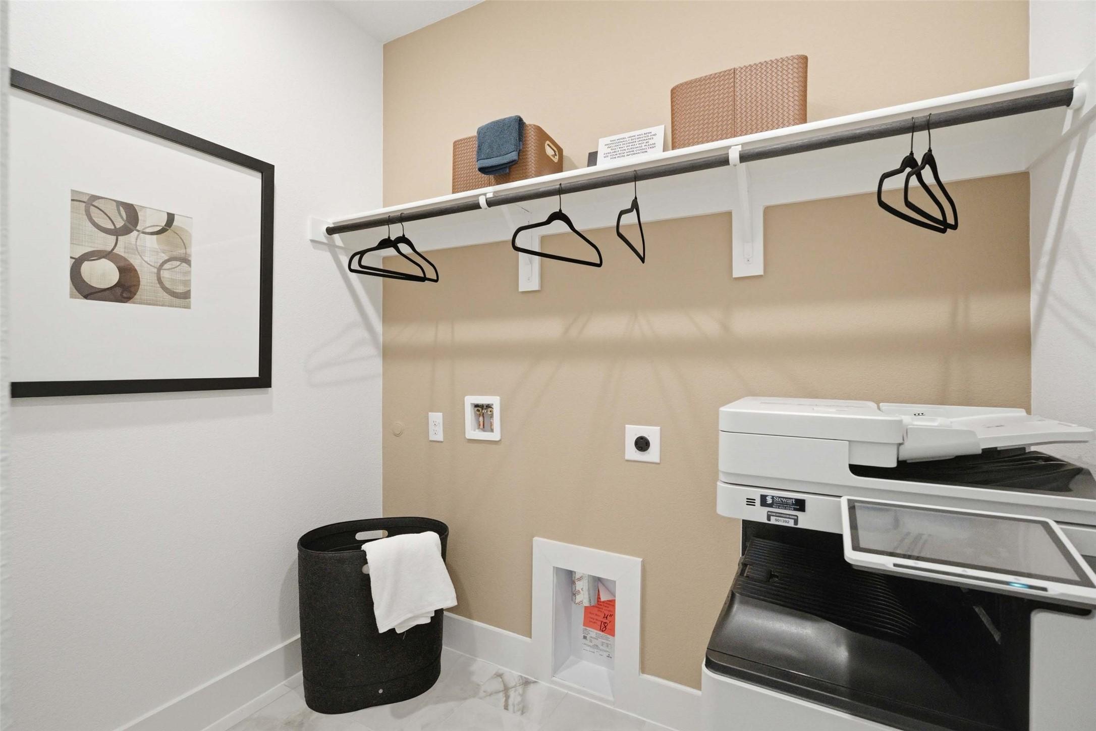 Laundry room with hanging rod, storage shelf, and washer in Davidson Homes The Laurel N plan, Mercer Meadows, Royse City, TX