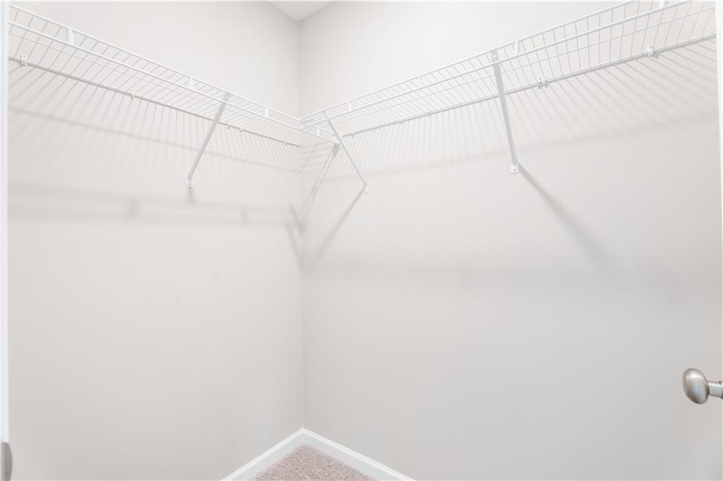 Spacious corner walk-in closet with white wire shelving in The Washington floor plan by Evermore Homes, Phenix City, Alabama